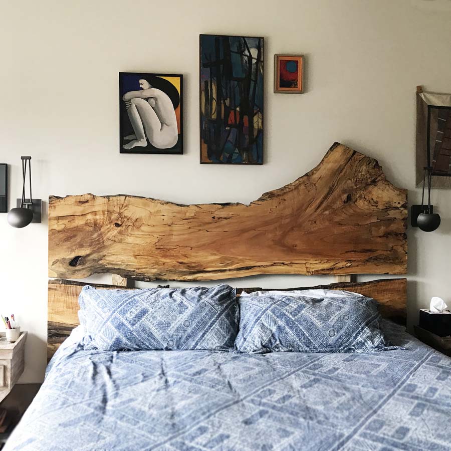 Live edge wood slab headboard with blue bedding