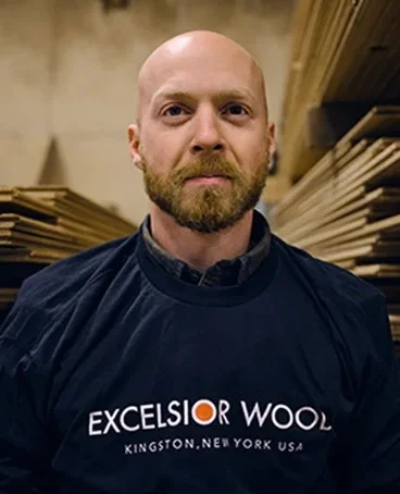 Ethan, a man with short brown hair and a beard, wearing a blue button-down shirt.